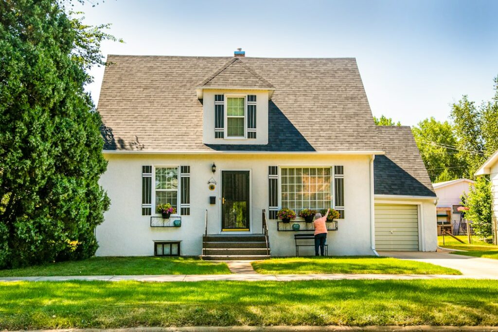 A resident checks a rental home’s exterior while inspecting gutters, windows, and outdoor fixtures.